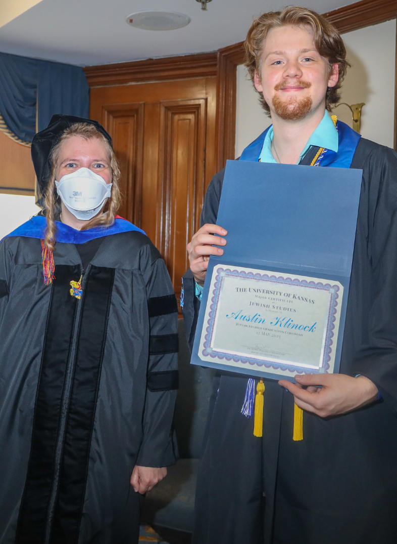 Austin Klinock holds his major certificate with Dr. Bogi Perelmutter at graduation.